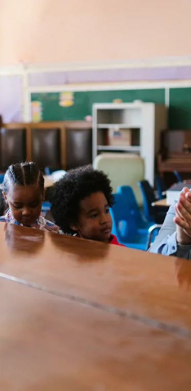 Éducateur avec un groupe d'enfants autour d'un piano