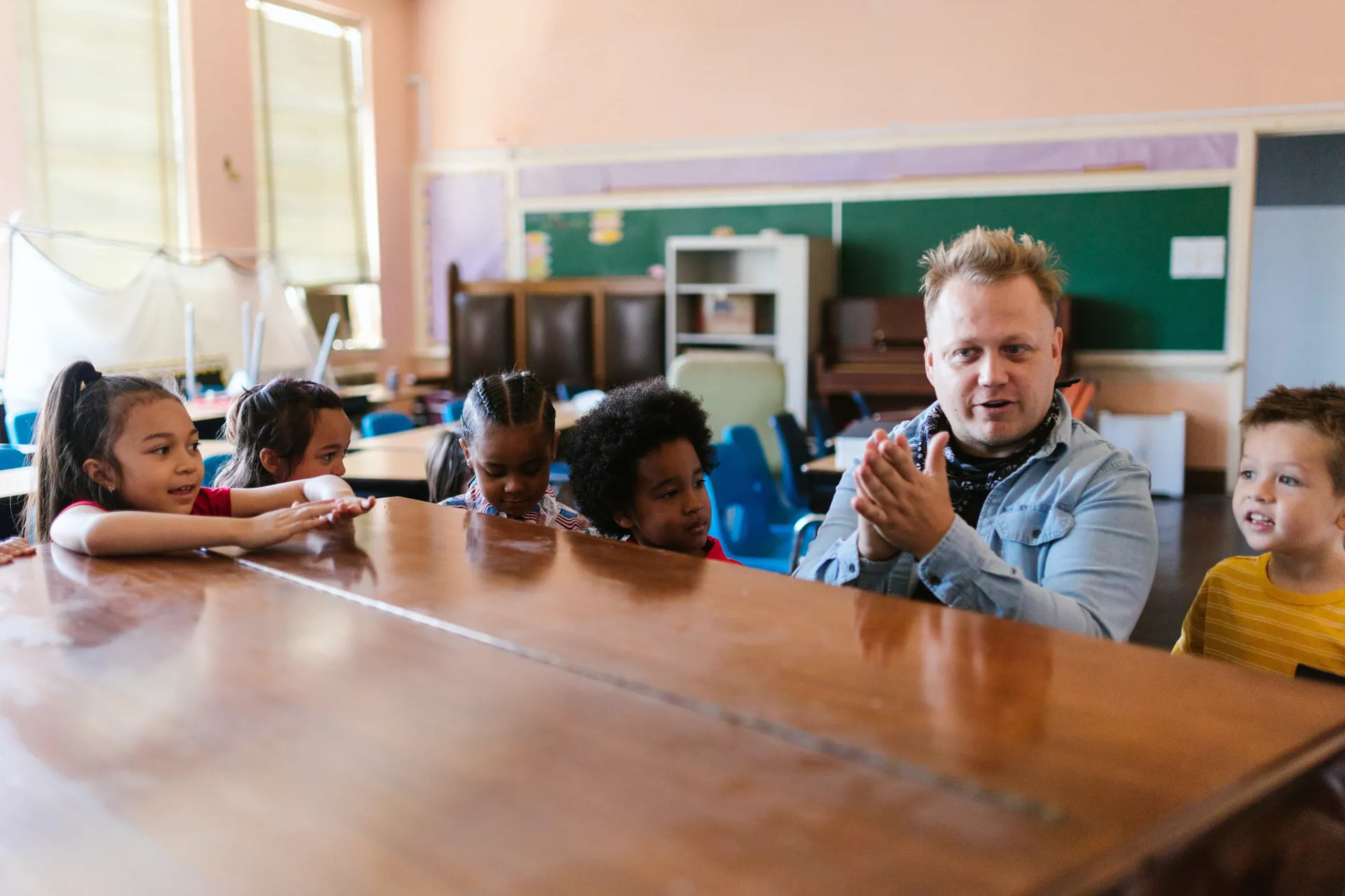 Éducateur avec un groupe d'enfants autour d'un piano